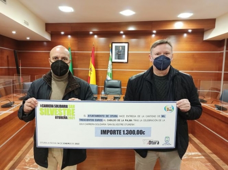 el alcalde de Otura y el concejal de Deportes posan con el cheque del dinero que se ha enviado al Cabildo de La Palma (AYTO. OTURA)