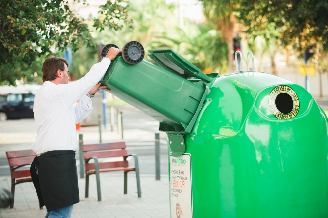 Hostelero reciclando vidrio (AYTO. HUÉTOR VEGA)
