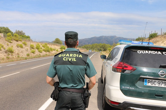 Un agente de la Guardia Civil, junto a un vehículo del cuerpo. (GUARDIA CIVIL)