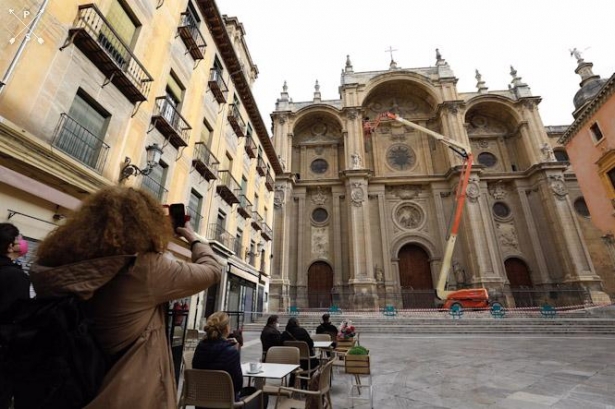 Varios operarios, subido a una grúa , revisan la fachada de la Catedral de Granada (ÁLEX CÁMARA/ EUROPA PRESS)