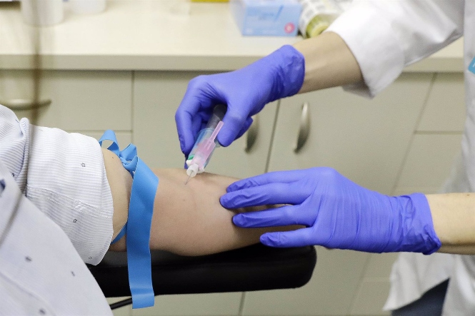 Un trabajador sanitario extrae sangre de una paciente (JOSEFINA BLANCO / EUROPA PRESS)