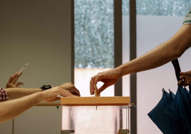 Una persona mete su voto en una urna (ROBER SOLSONA / EUROPA PRESS)