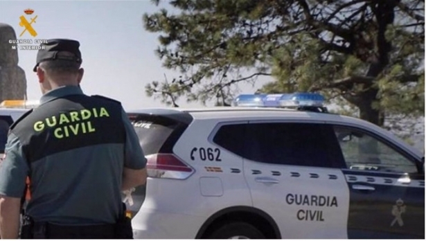 Agente de la Guardia Civil ante un coche patrulla, en imagen de archivo (GUARDIA CIVIL DE VALLADOLID)