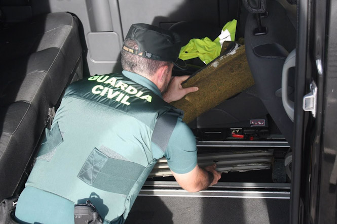 Agente de la Guardia Civil registrando un vehículo (GUARDIA CIVIL)