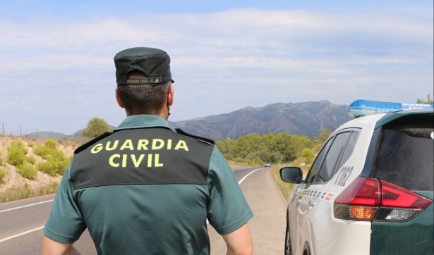Un agente de la Guardia Civil junto a un vehículo en una carretera (GUARDIA CIVIL) Un agente de la Guardia Civil junto a un vehículo en una carretera (GUARDIA CIVIL)