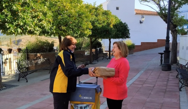 Cartera atiende a una usuaria en la calle de un pueblo (CORREOS) Cartera atiende a una usuaria en la calle de un pueblo (CORREOS)
