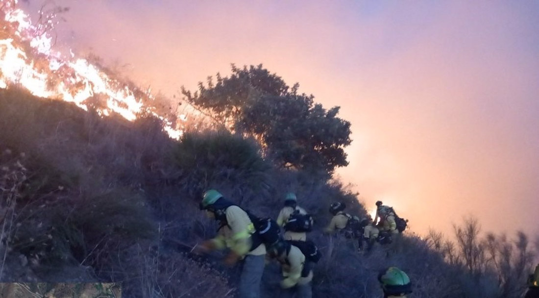 Bomberos del Plan Infoca trabajan para sofocar las llamas en las escarpadas laderas de Peña Escrita (PLAN INFOCA)