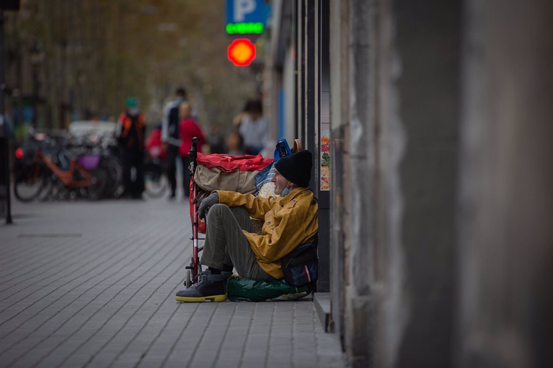 Una persona sin techo permanece en el suelo de una calle (DAVID ZORRAKINO / EUROPA PRESS)