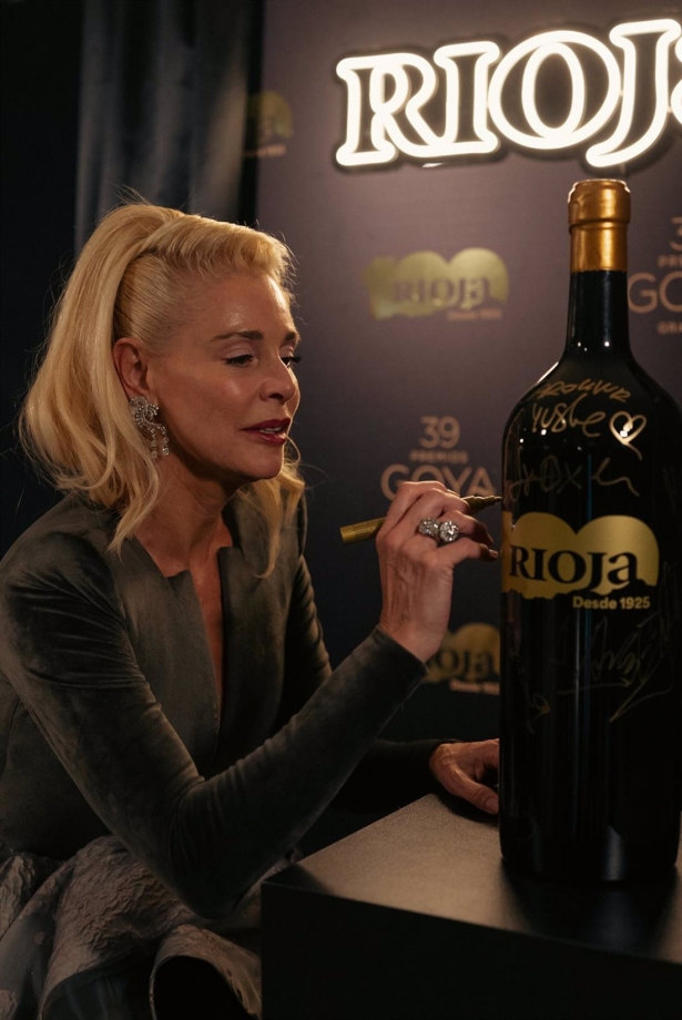 La actriz Belén Rueda firma una de las botellas especiales de Rioja del centenario que han desaparecido tras los Goya (DOCA RIOJA)