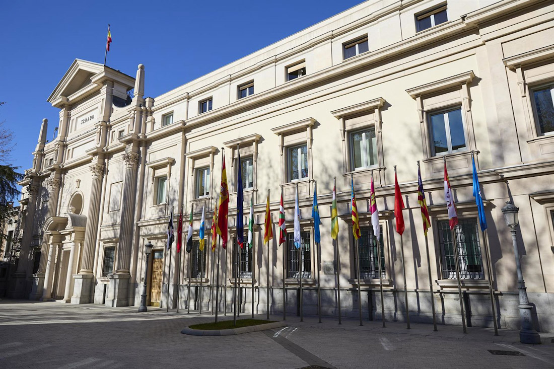 Banderas de las Comunidades Autónomas frente a la fachada del Palacio del Senado (JESÚS HELLÍN - EUROPA PRESS)