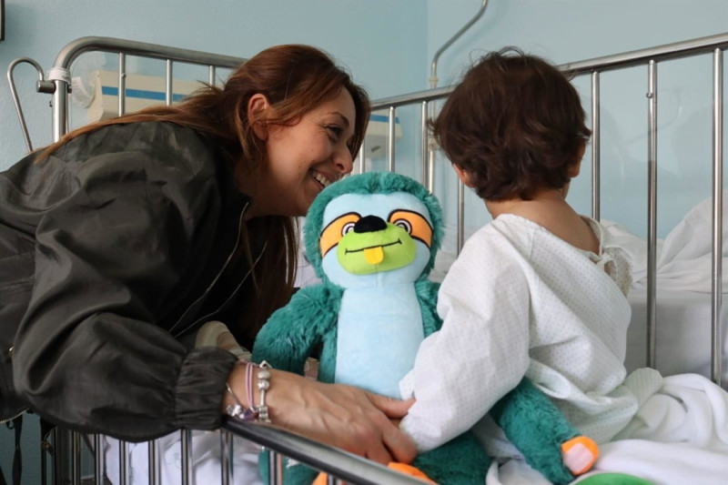 Una mama con su pequeña abrazan a Quiro antes de una intervención.