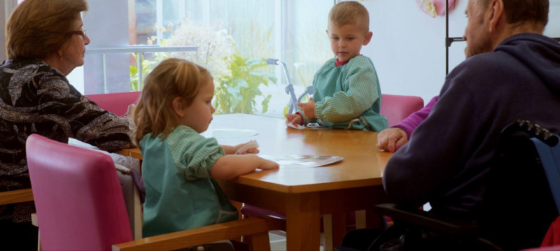 Niños y mayores comen juntos.