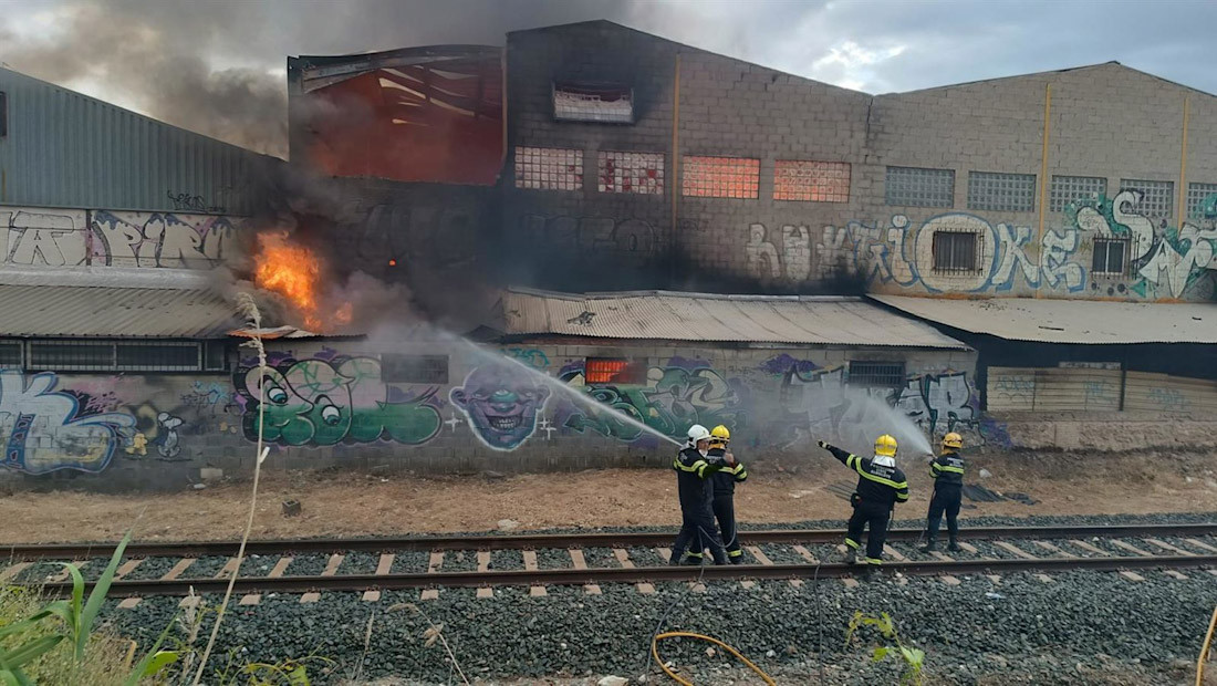 Imagen cedida por Protección Civil de Peligros (Granada) en la que se puede ver a los bomberos trabajando en las tareas de extinción del incendio declarado en una nave industrial de la localidad (PROTECCIÓN CIVIL)PELIGROS