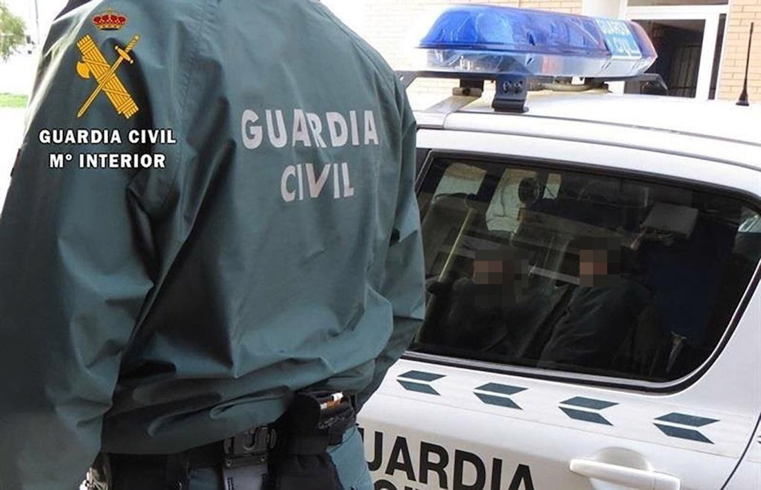 Un agente de la Guardia Civil junto a un coche patrulla (GUARDIA CIVIL)