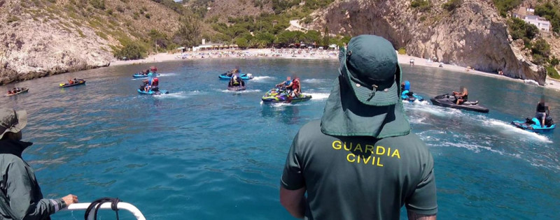 Agente de la Guardia Civil junto a varias motos acuáticas (GUARDIA CIVIL) Agente de la Guardia Civil junto a varias motos acuáticas (GUARDIA CIVIL)